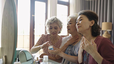 Senior Chinese friends applying moisturizer at home,4K