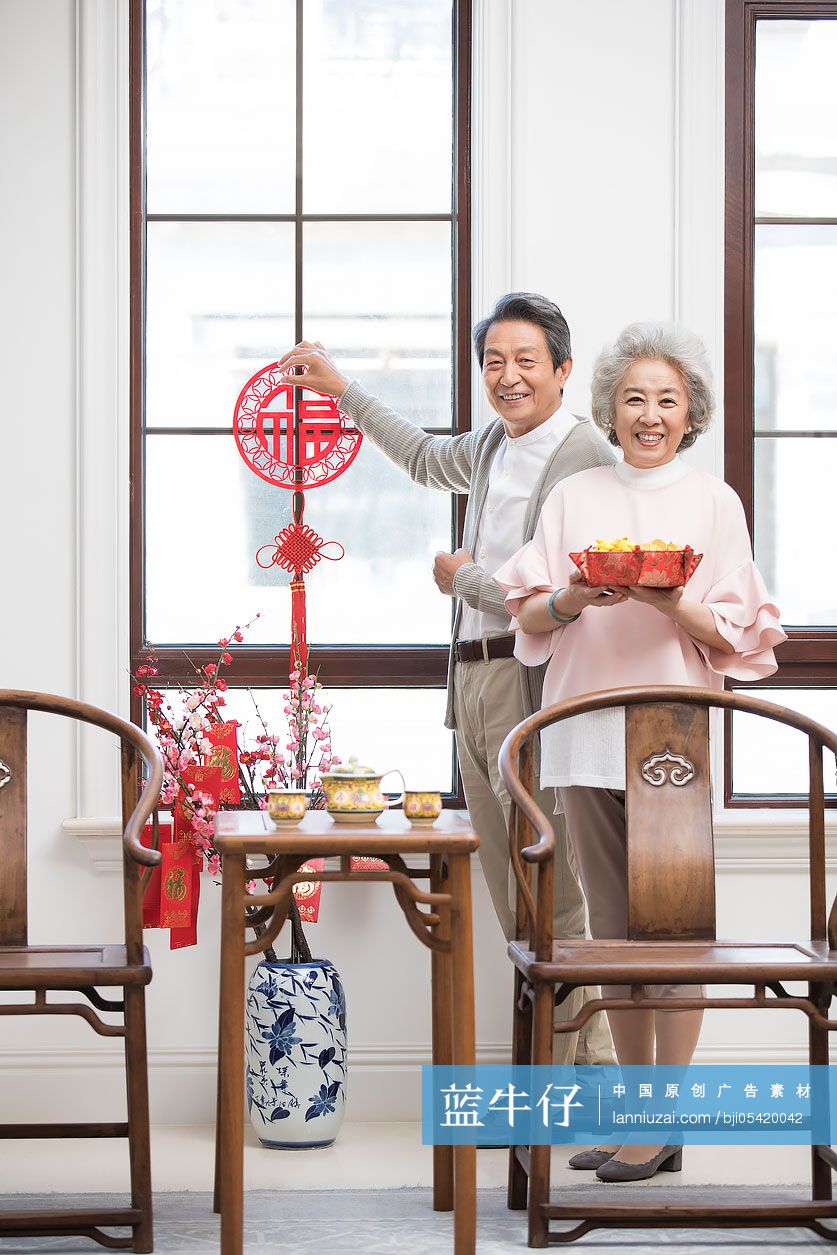 快乐的老年夫妇在家布置新年装饰-蓝牛仔影像-中国原创广告影像素材