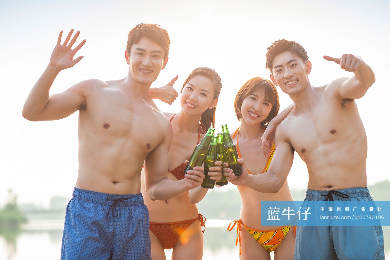 快乐的年轻人在湖边喝啤酒