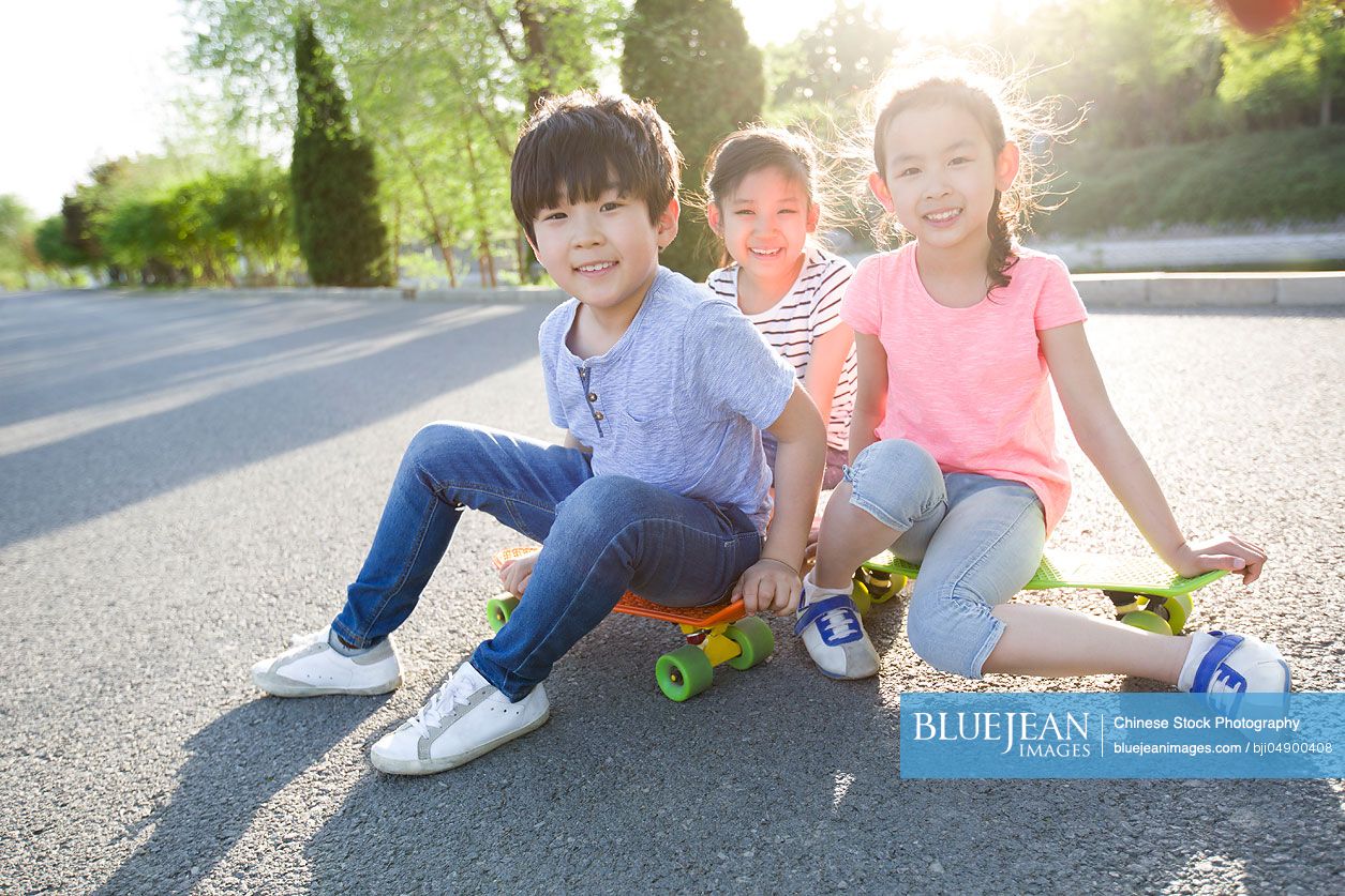 Happy Chinese Children Sitting On Skateboards High Res Stock Photo For