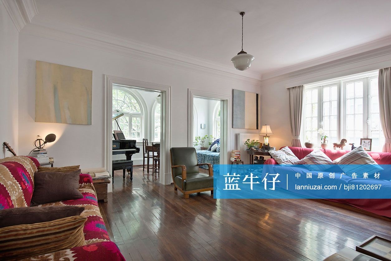 Spacious living room with wooden floor and piano in the neighboring room at home