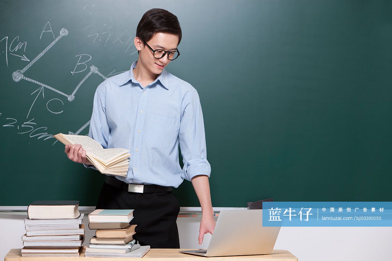 男老师在教室使用笔记本电脑