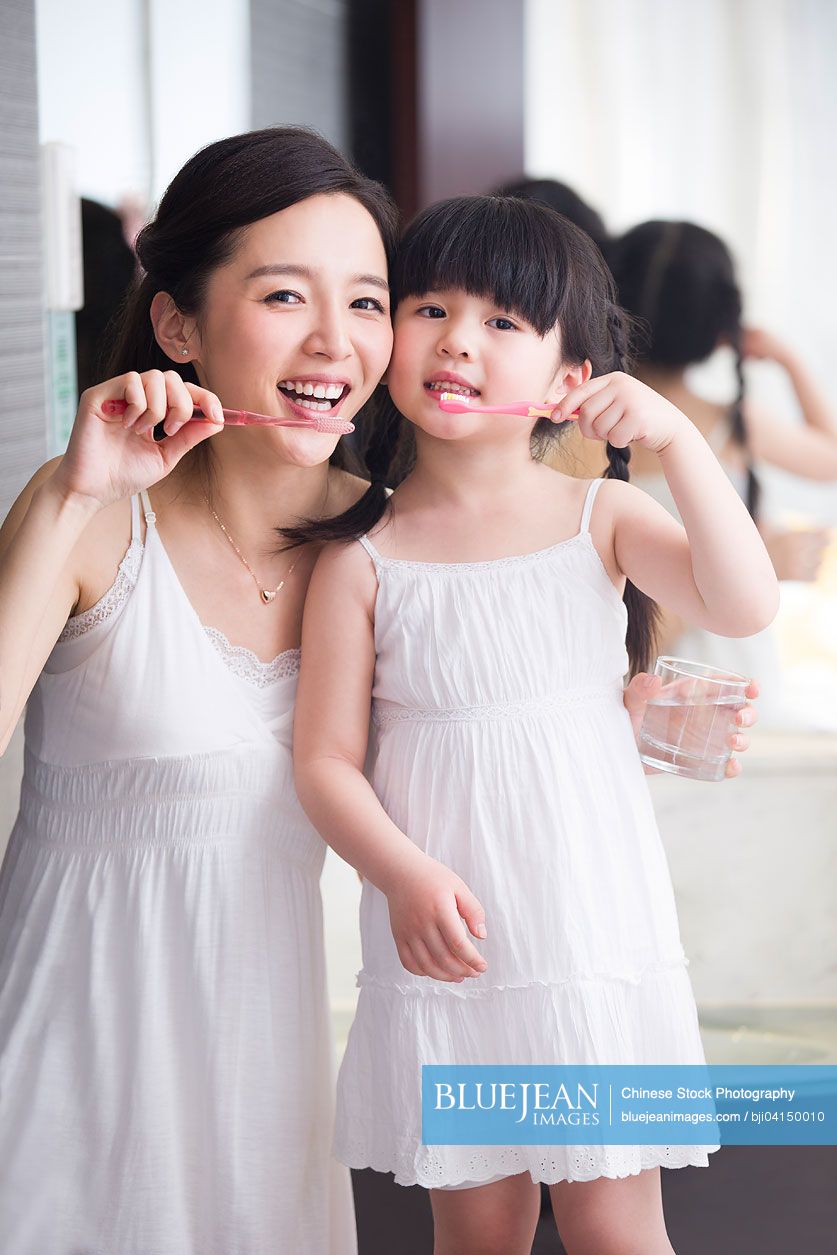 Chinese mother and daughter brushing teeth