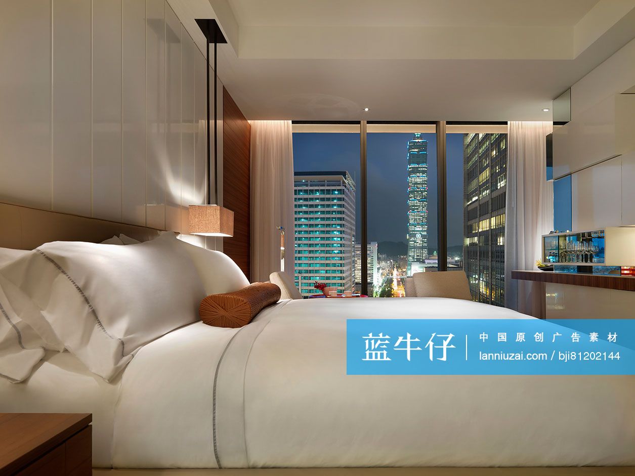 Contemporary hotel bedroom with city view at night