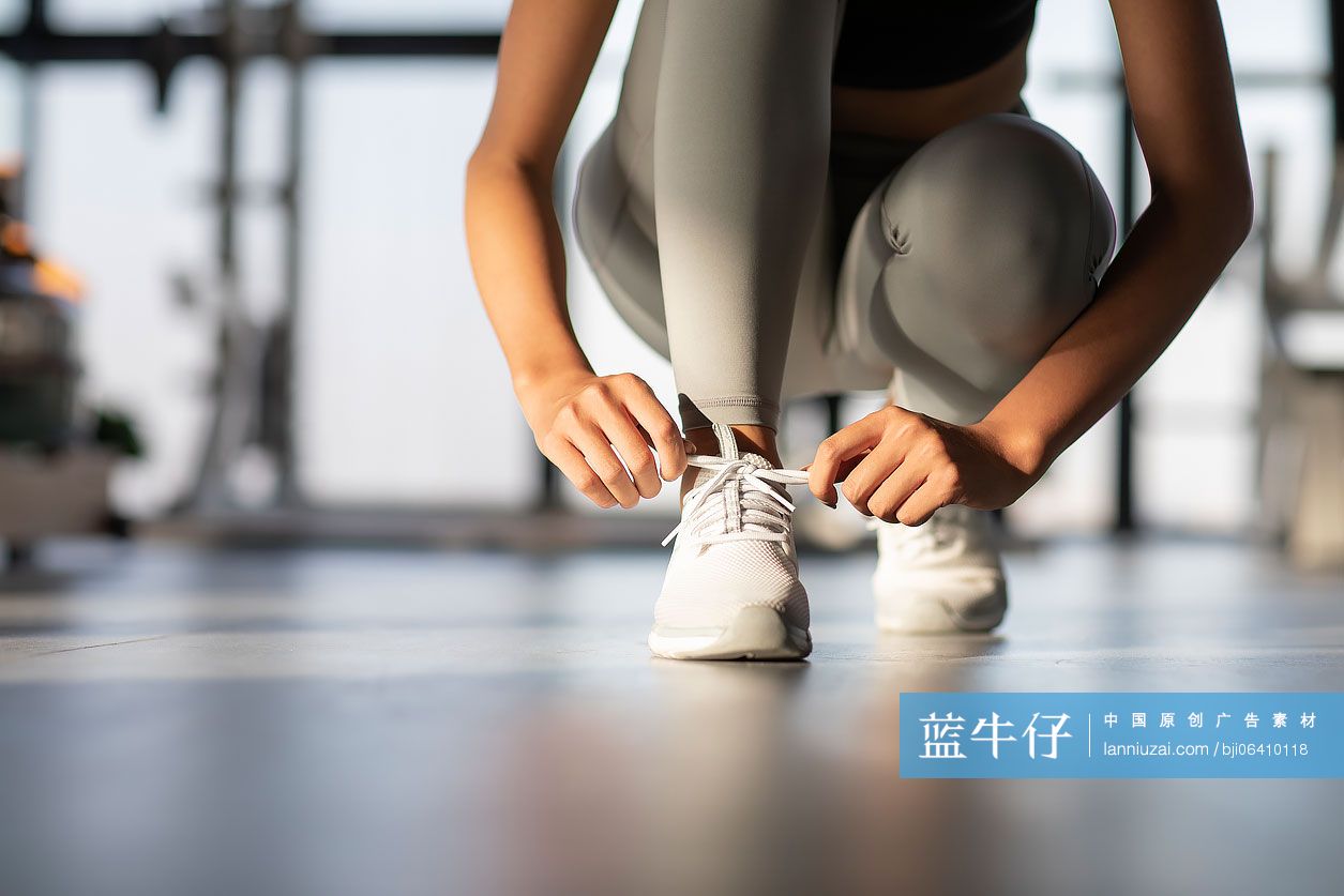 年轻女士在健身房系鞋带