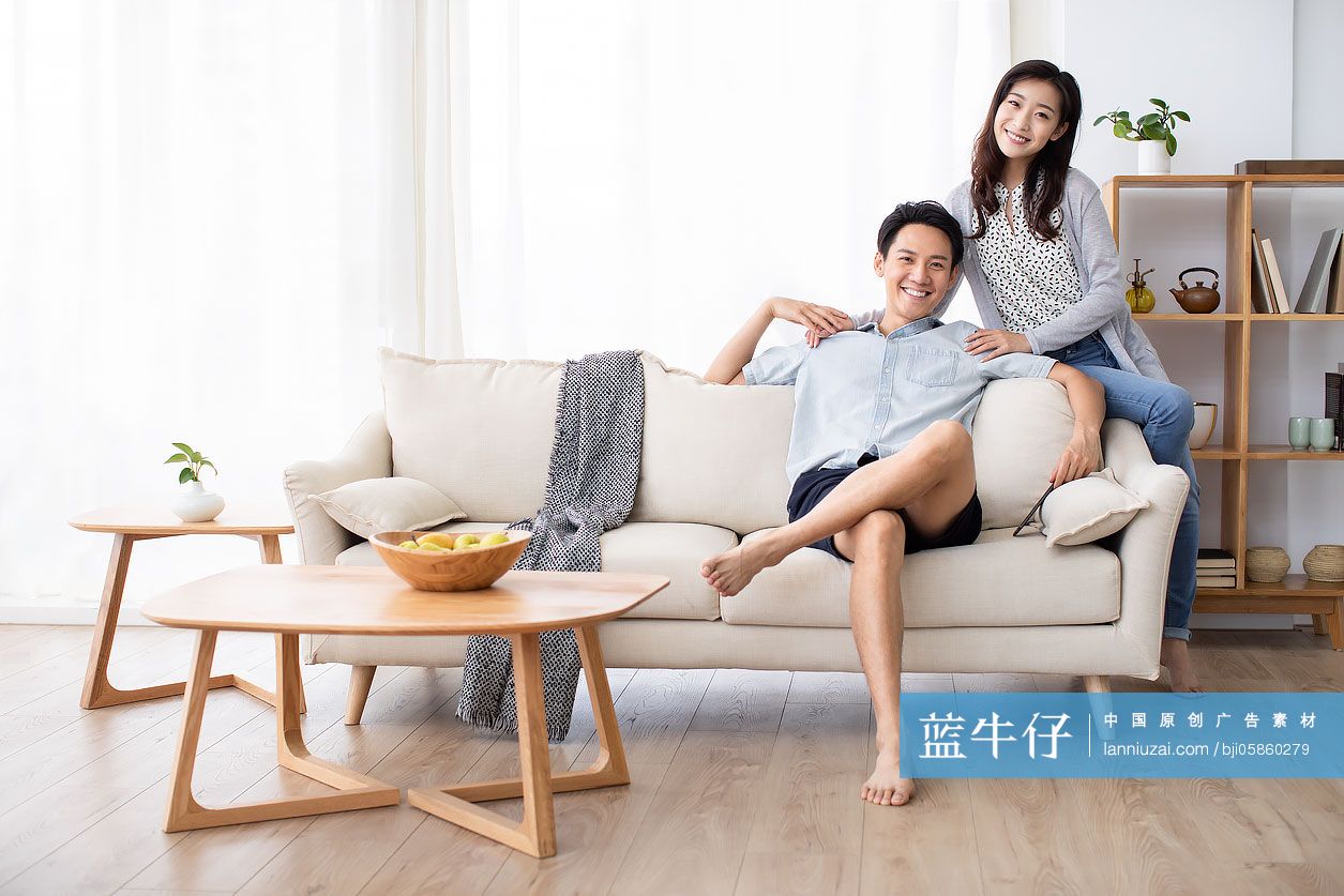 快乐的年轻情侣在客厅玩手机