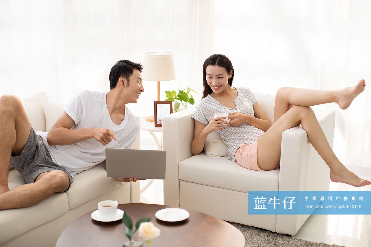 年轻情侣在客厅使用笔记本电脑-蓝牛仔影像-中国原创广告影像素材
