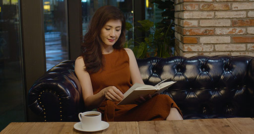 Elegant Chinese woman reading book in coffee shop,4K