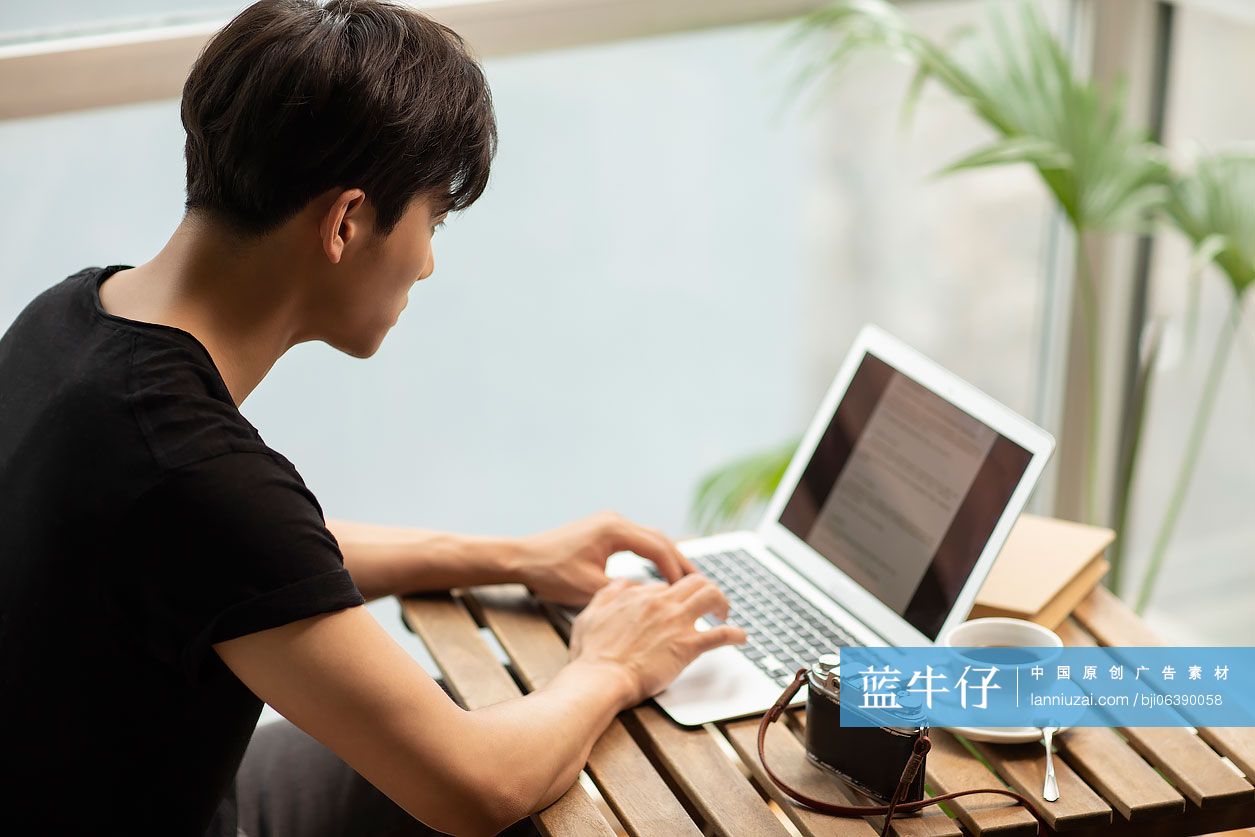 年轻摄影师在家使用笔记本电脑