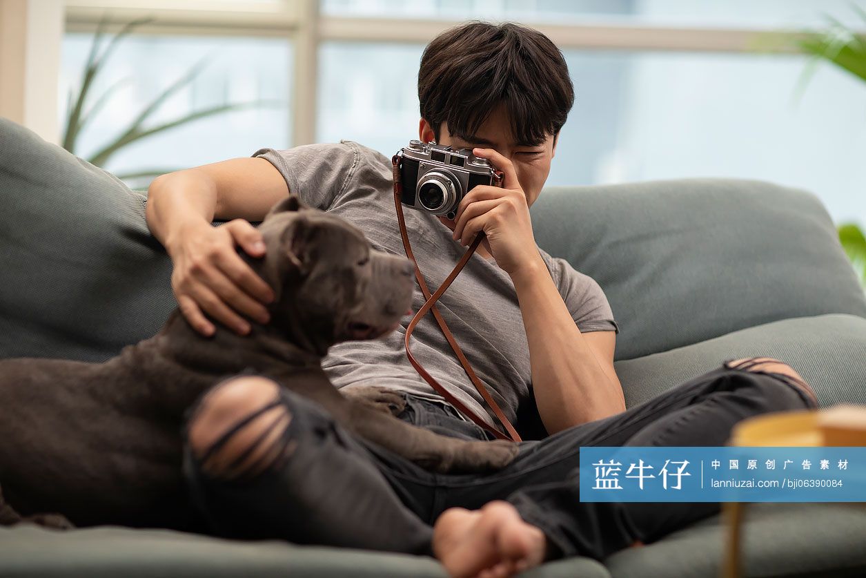 年轻男士和宠物狗在沙发上