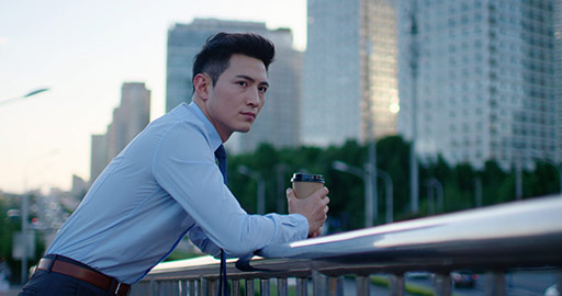 Young Chinese businessman holding a cup of coffee outdoors,4K