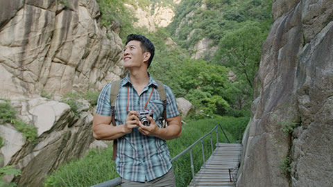 Happy young Chinese man taking photos outdoors,4K