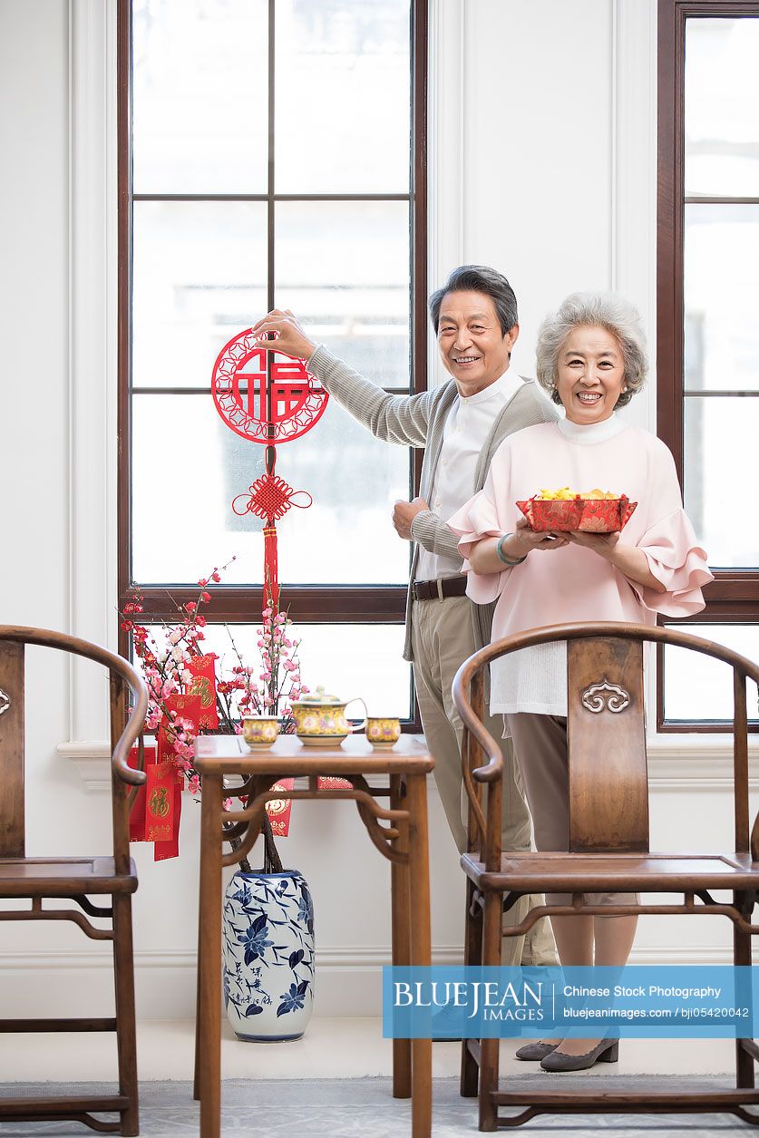 Senior couple decorating their house for Chinese New Year