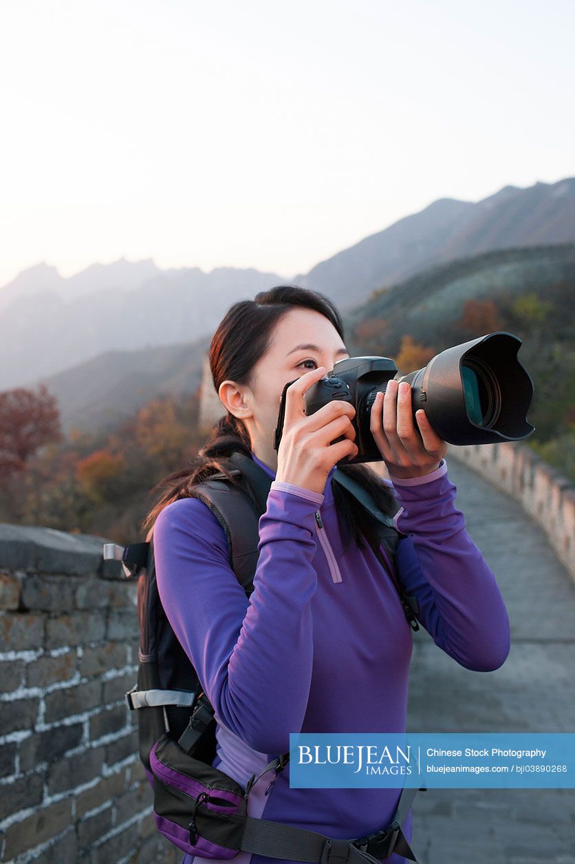 Young Chinese woman photographing on Great Wall