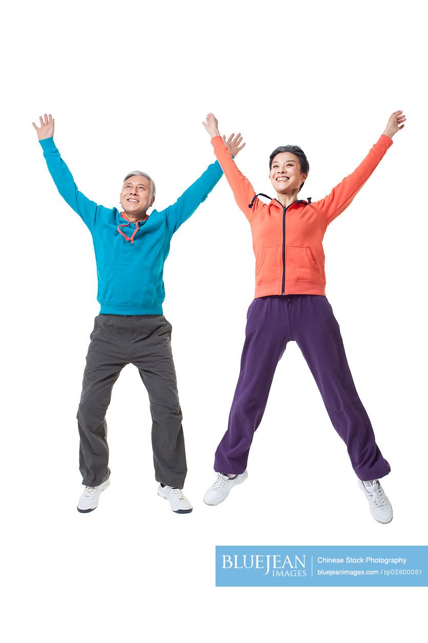 Senior Chinese couple jumping in the mid-air