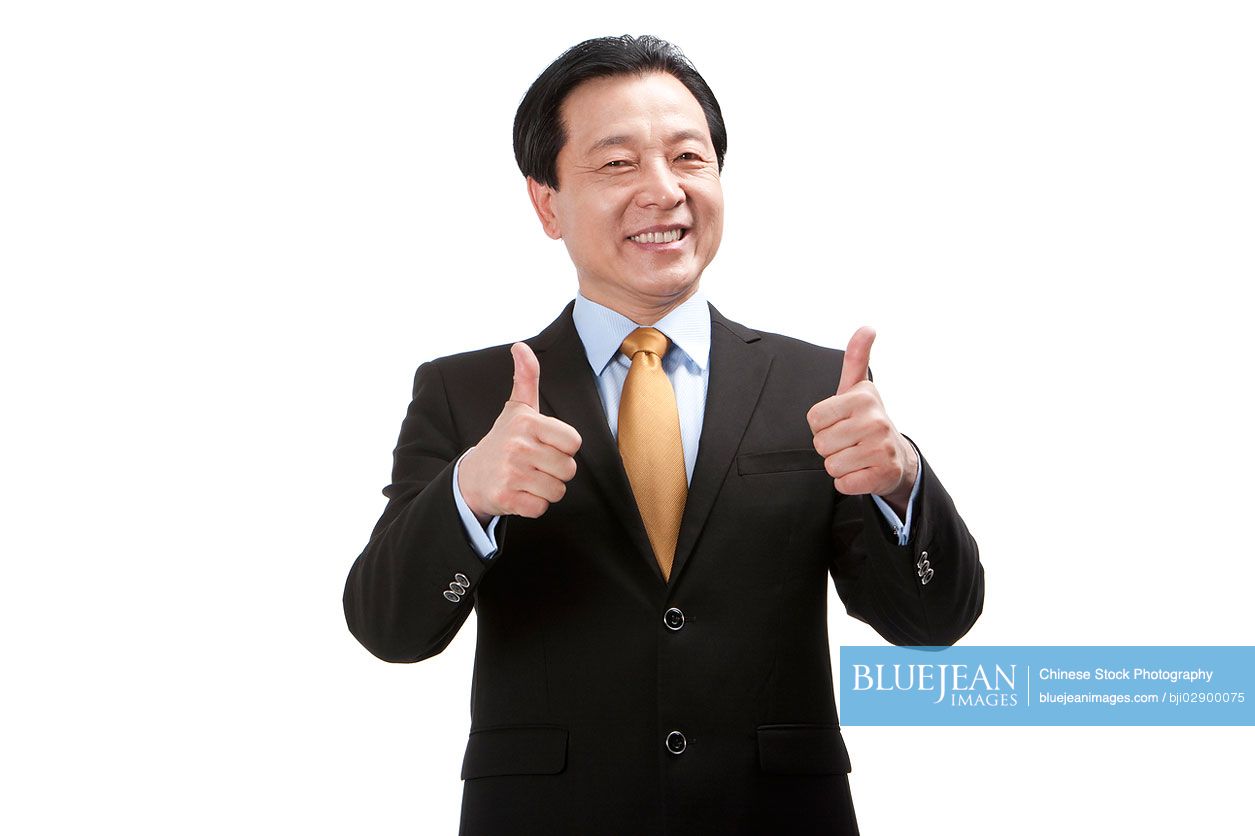 Senior Chinese businessman doing thumbs-up