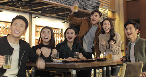 Happy young Chinese friends drinking beer at bar,4k