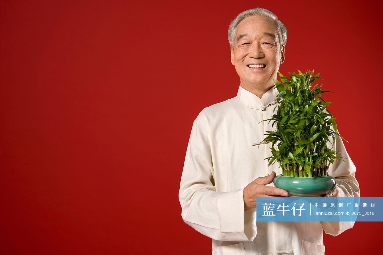 一位老人手拿一盆竹子
