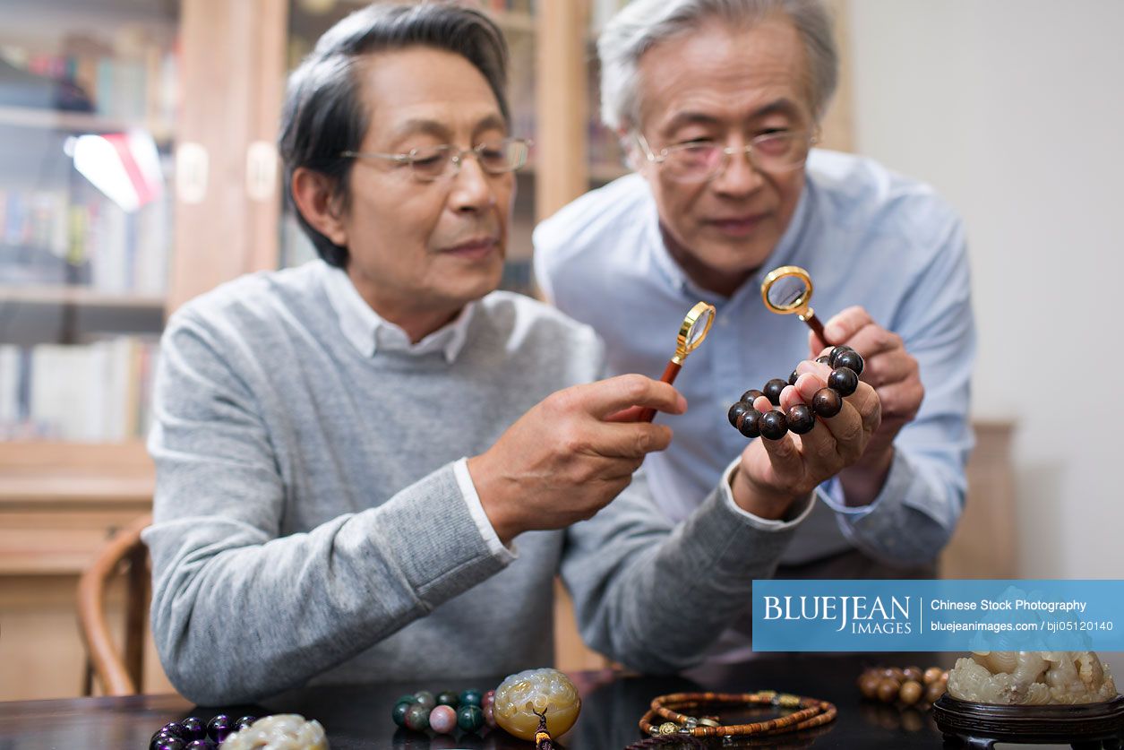 Senior Chinese men admiring antiques
