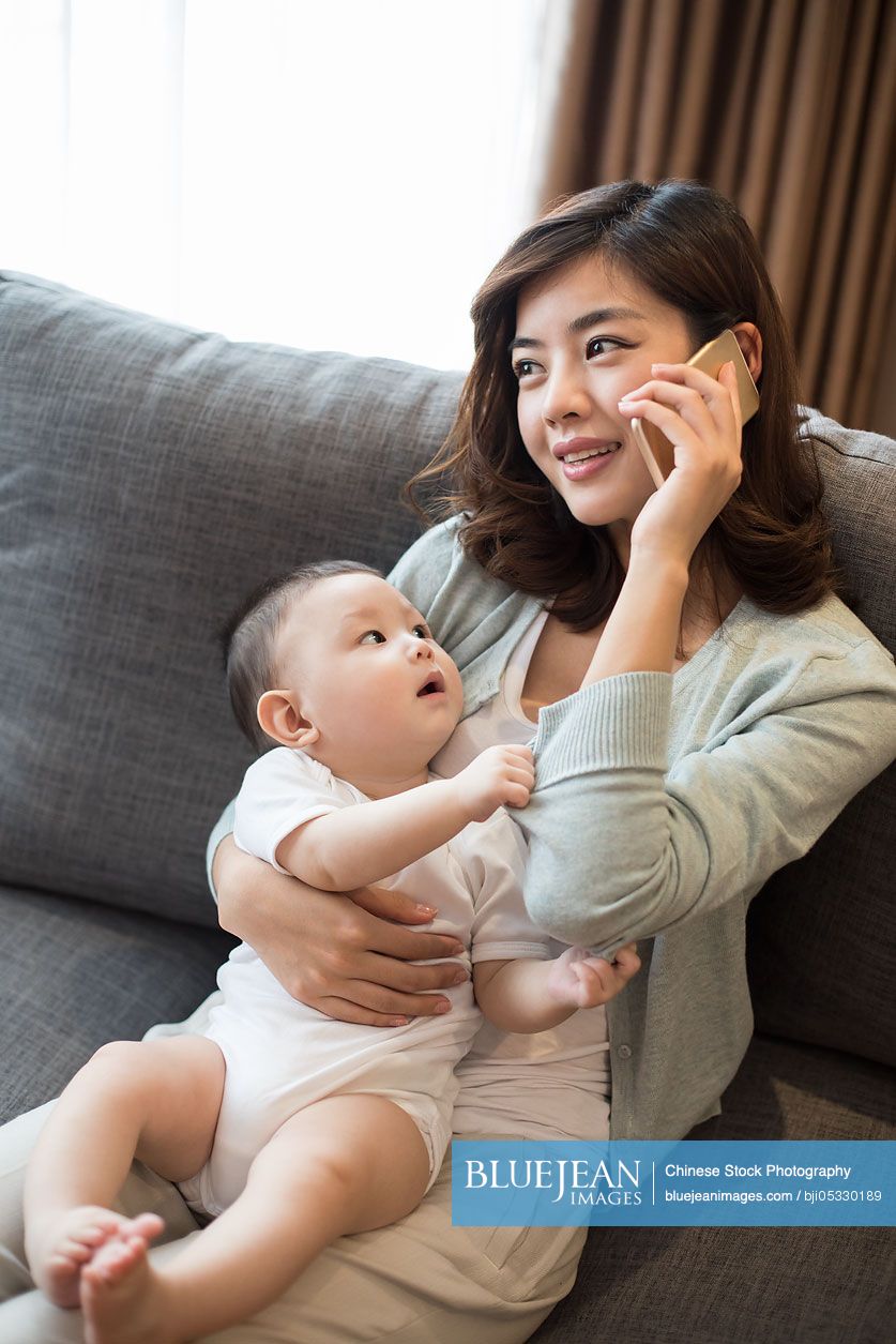 Happy Chinese mother and cute baby at home