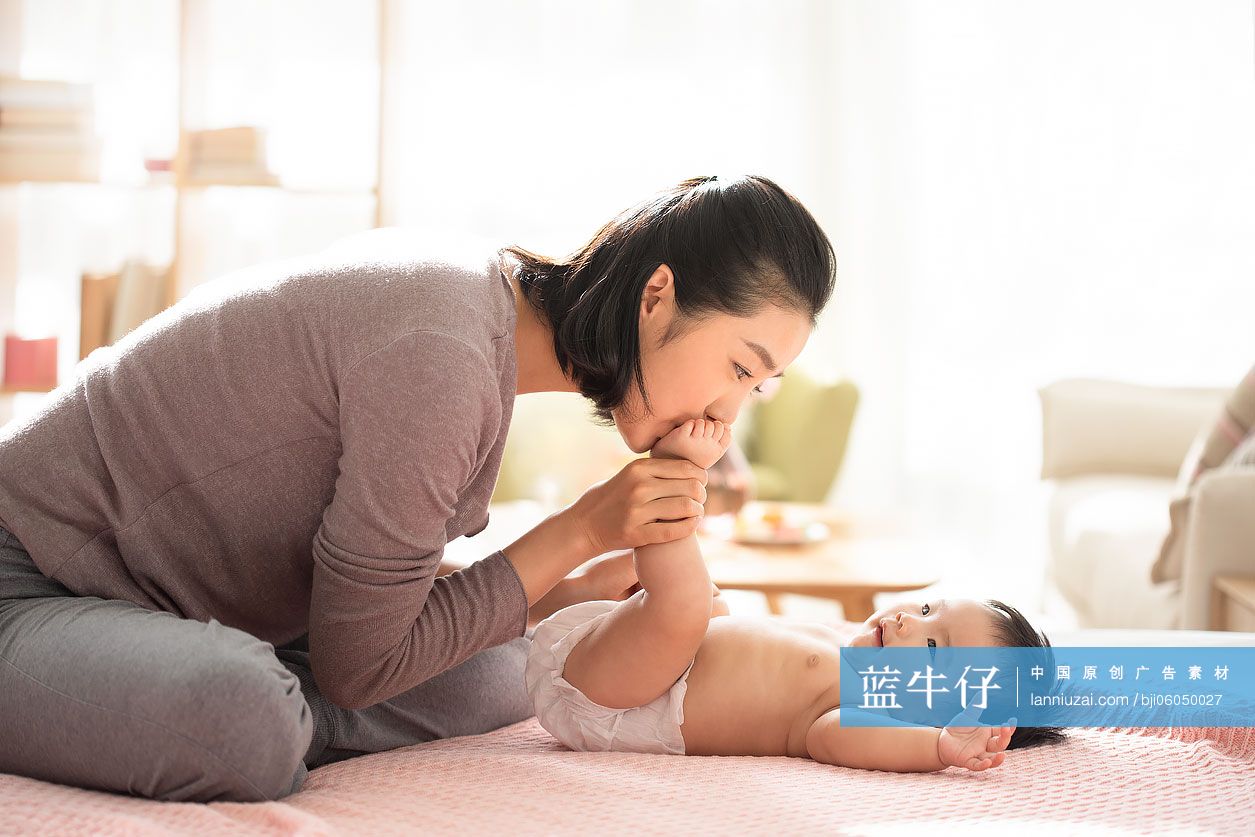 年轻的母亲亲吻婴儿