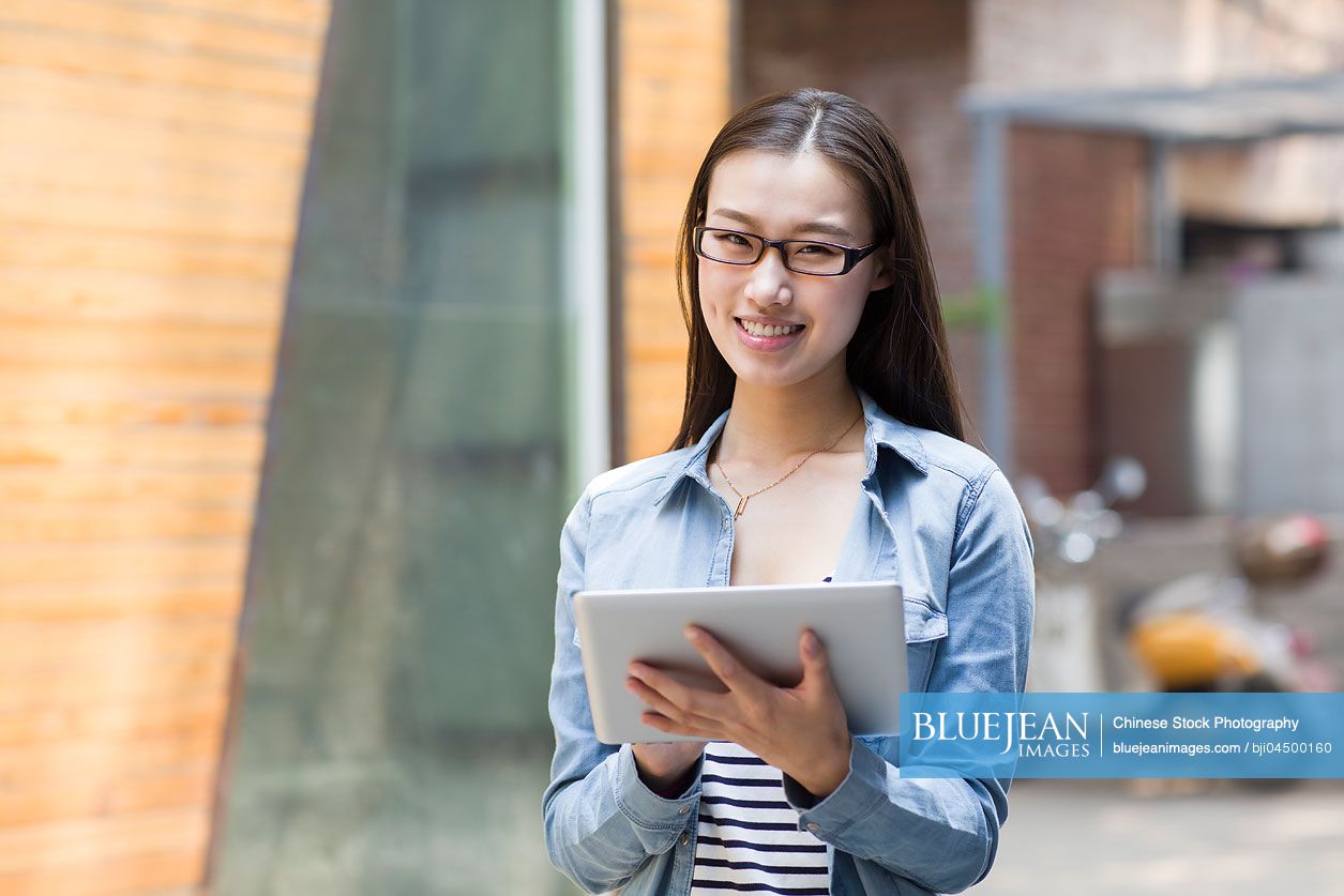 Young Chinese woman holding a digital tablet