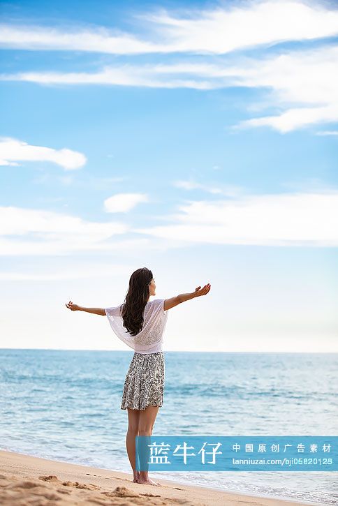 年輕女性在海邊張開雙臂