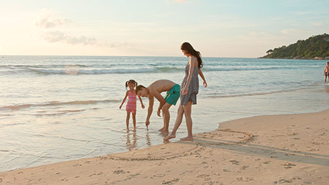 快乐的年轻家庭在沙滩玩耍