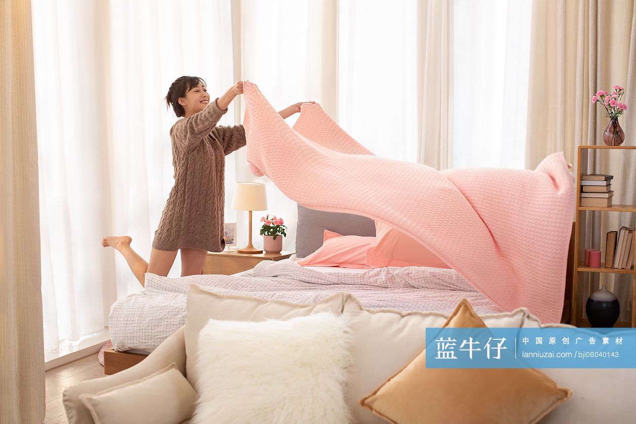 年轻女士整理床铺