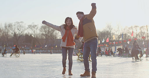 Happy young Chinese couple playing on ice,4K