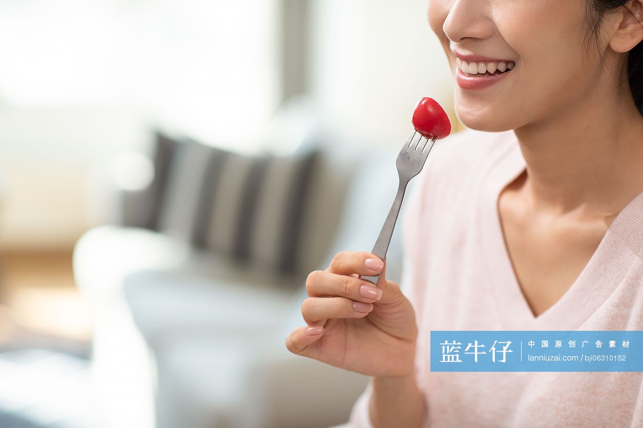 快乐年轻女士在家吃沙拉