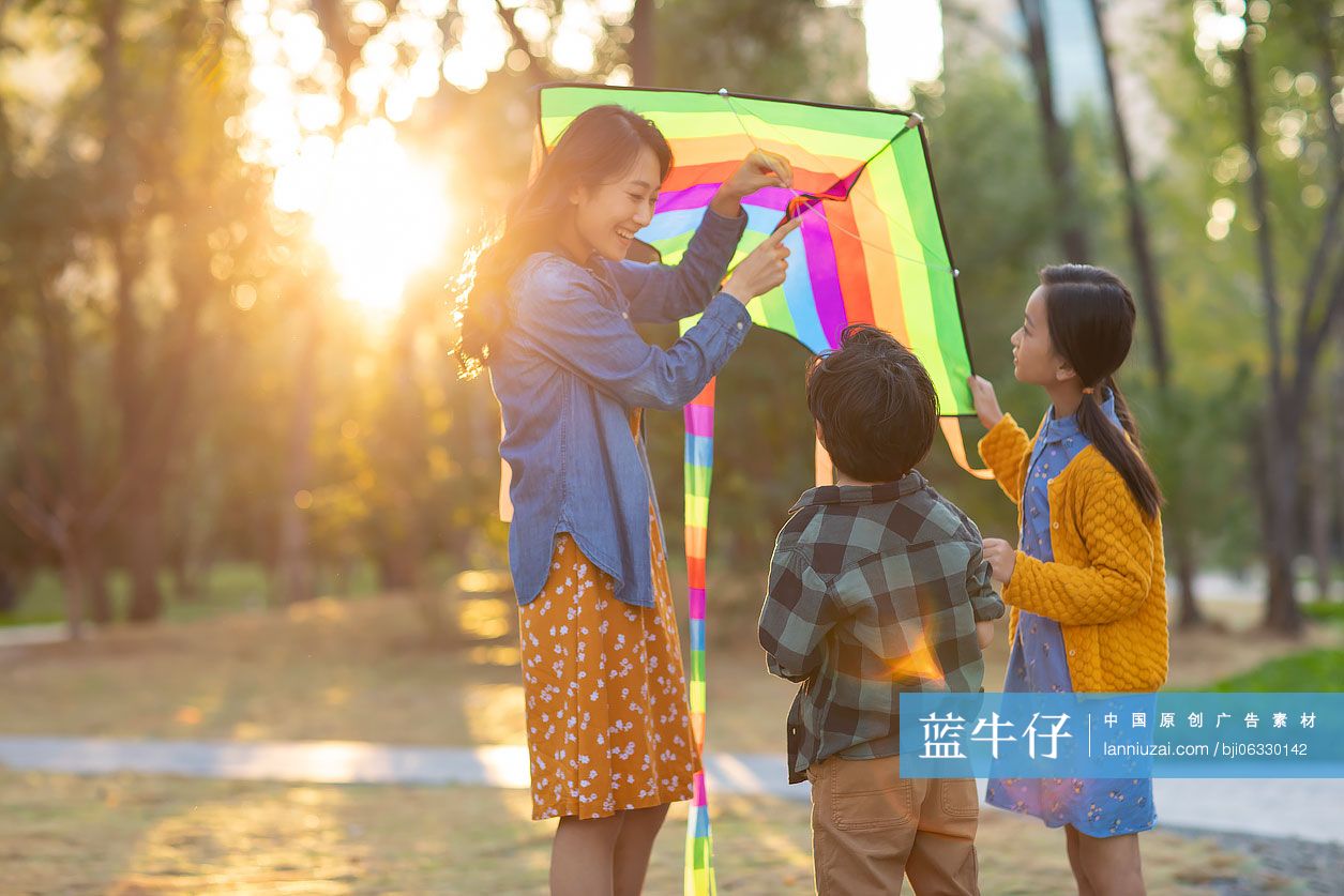 快乐的年轻家庭在公园放风筝