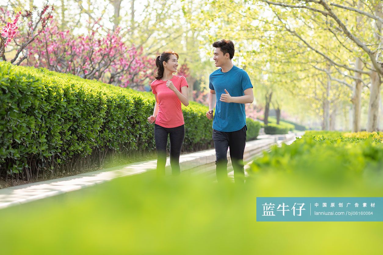 快乐的年轻情侣在公园跑步