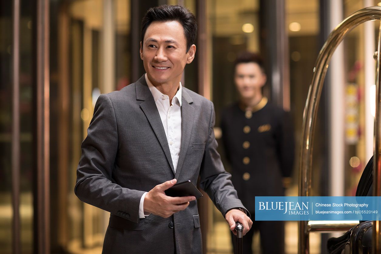 Cheerful Chinese businessman in hotel lobby