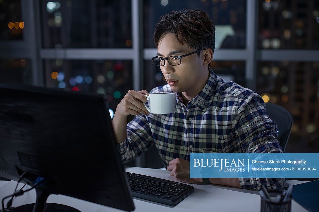 Chinese IT worker working in office at night