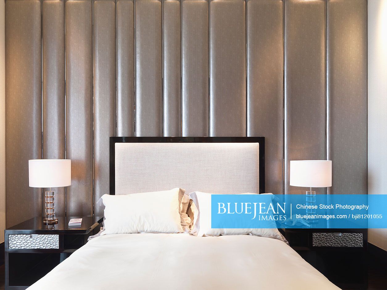 Symmetrical view of bed headboard and nightstands with lamps