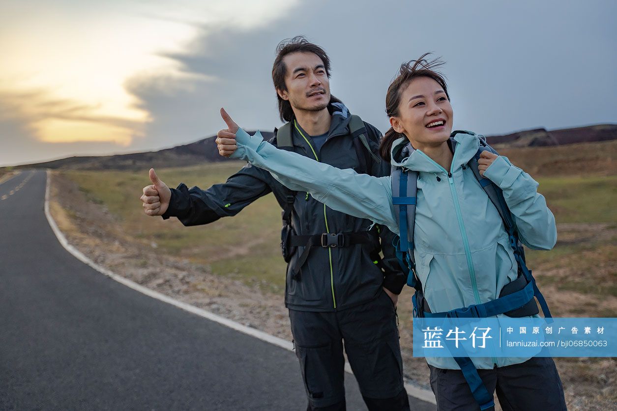 徒步旅行的情侣做搭便车手势