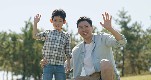 Happy Chinese father and son relaxing on meadow,4K