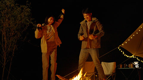 Happy young Chinese couple camping outdoors