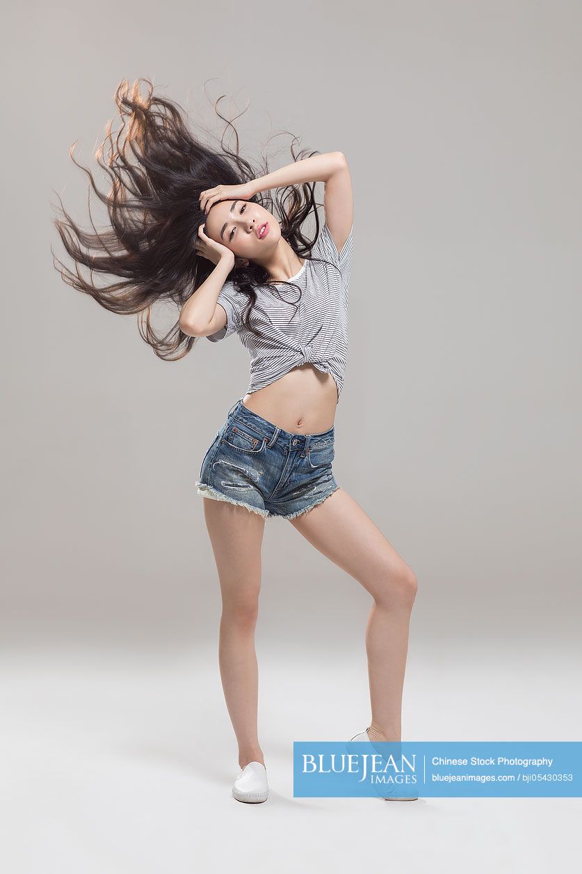 Happy young Chinese woman dancing