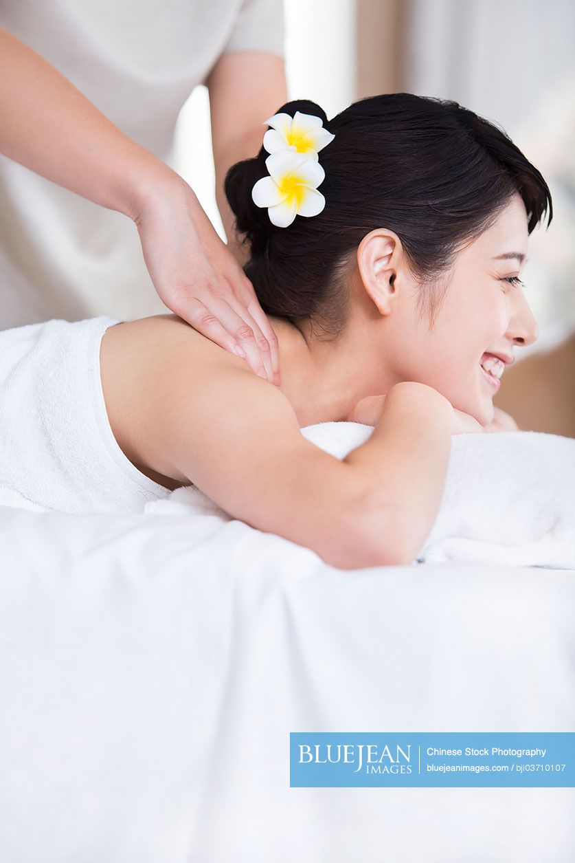 Young Chinese woman enjoying back massage