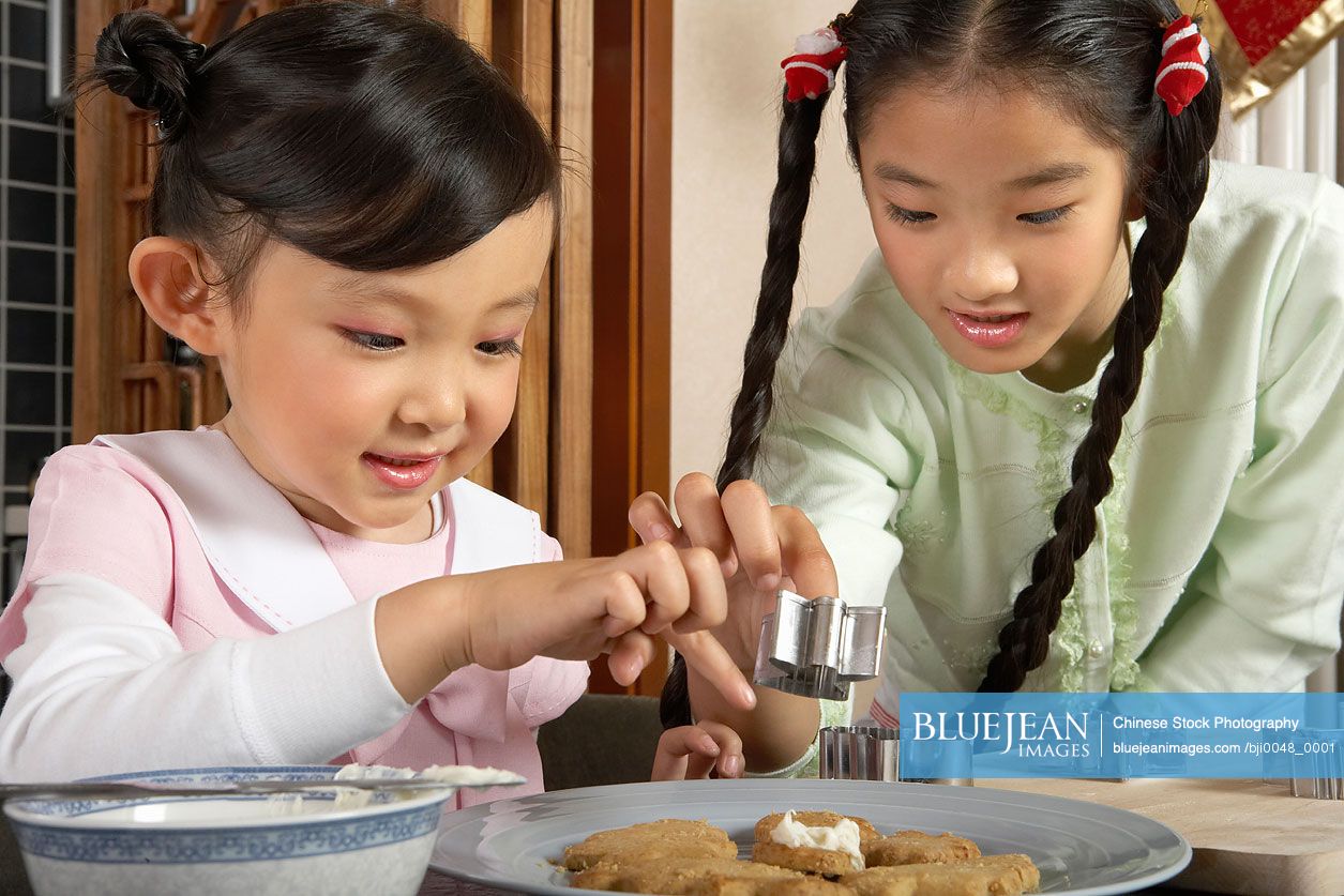 Chinese girl baking and using a cookie cutter