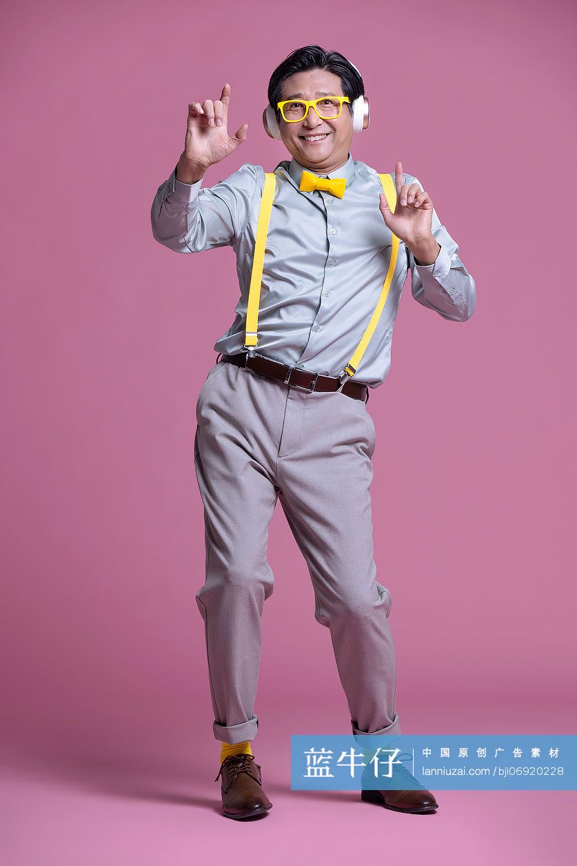 幽默时尚的老年男子戴着耳机听音乐