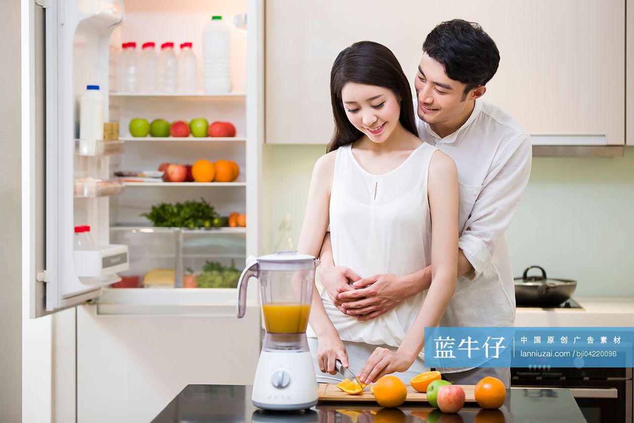 年轻夫妇在厨房切橙子