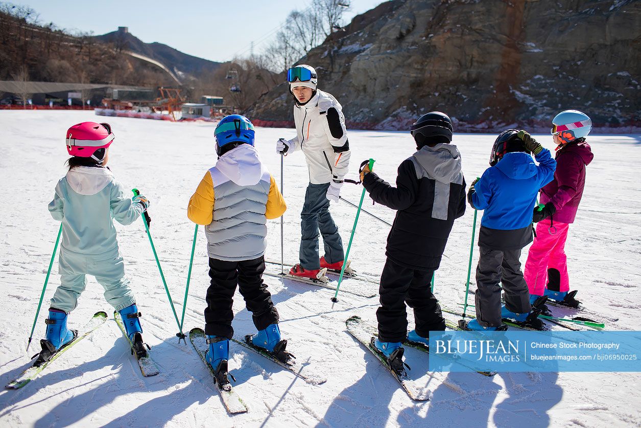 Chinese children learning how to ski with their coach