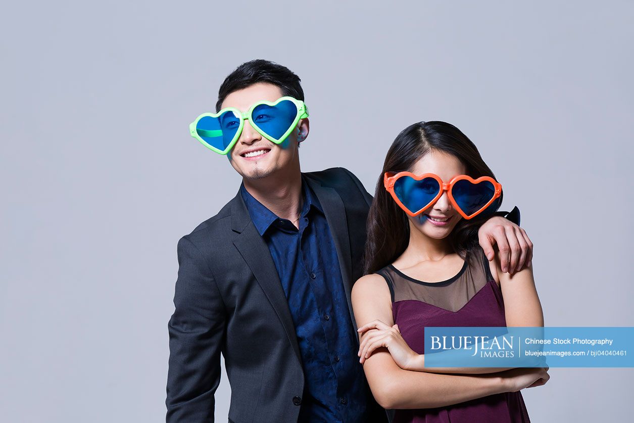 Happy young Chinese couple with big sunglasses