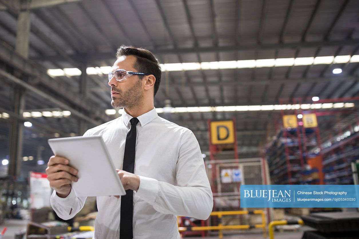 Businessman holding a digital tablet in the factory