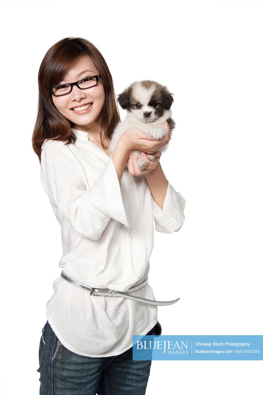 Portrait of young Chinese woman with Shih Tzu puppy