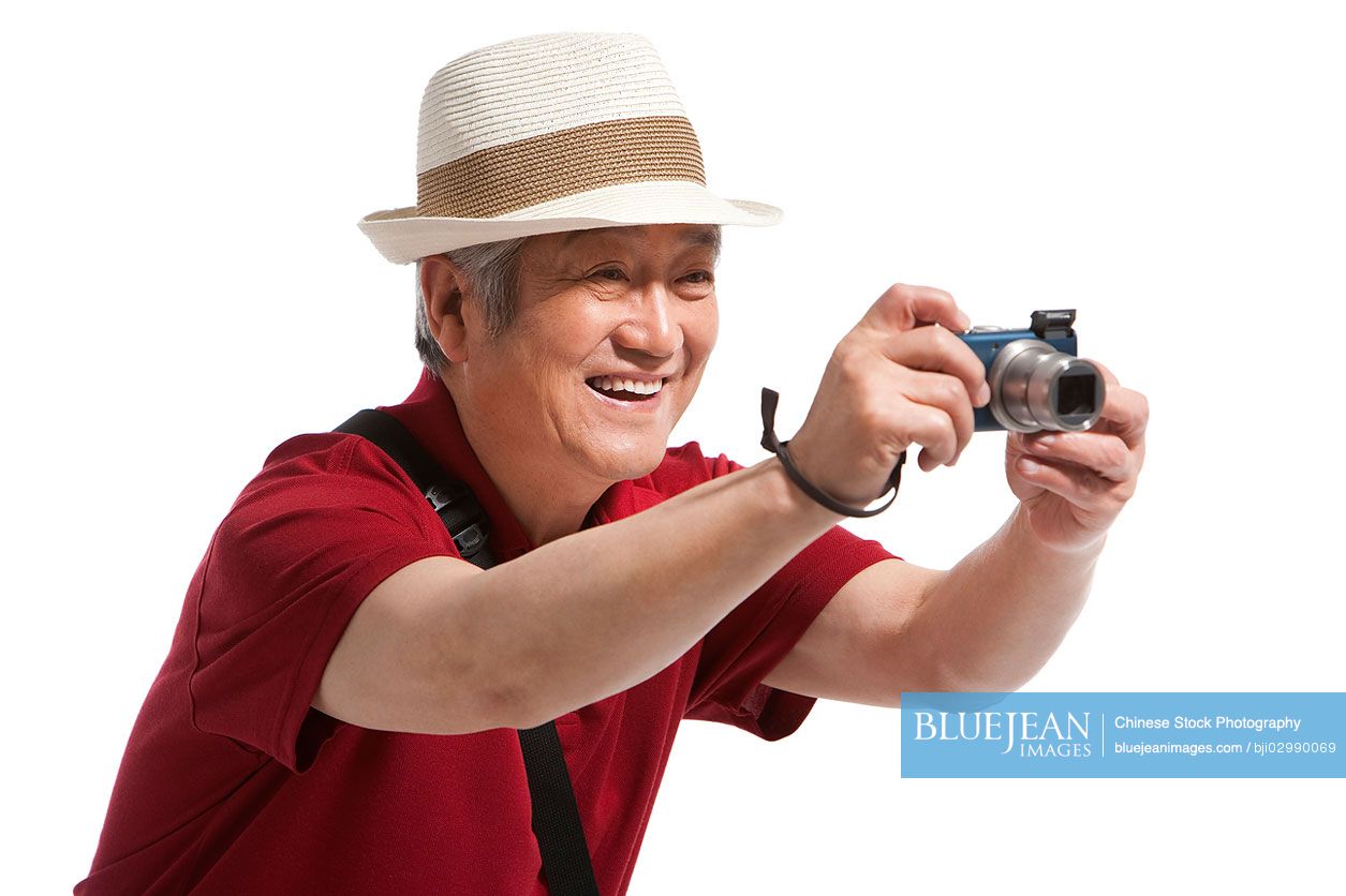 Portrait of senior Chinese man holding a camera