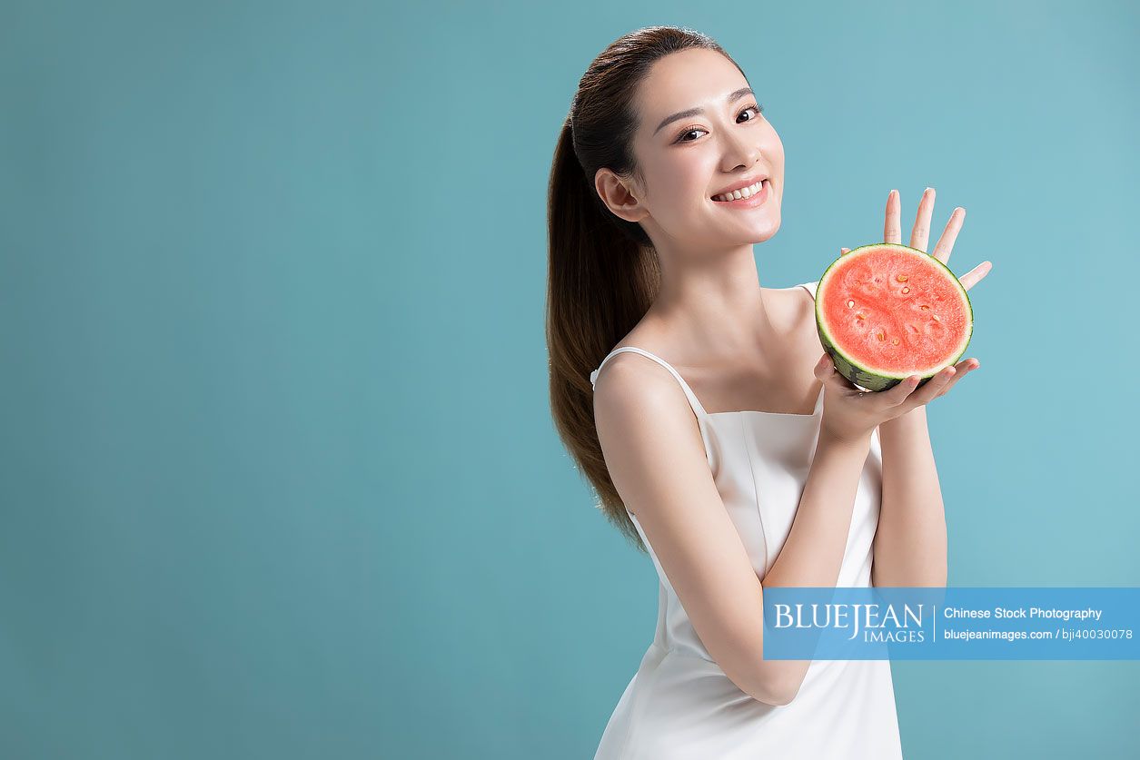 Beautiful young Chinese woman with watermelon